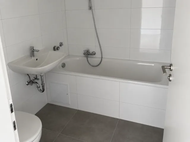 Referenzfoto im Album Bad & Sanitär: Echtes Referenzfoto eines fertiggestellten Badezimmers mit weißen Fliesen und Badewanne