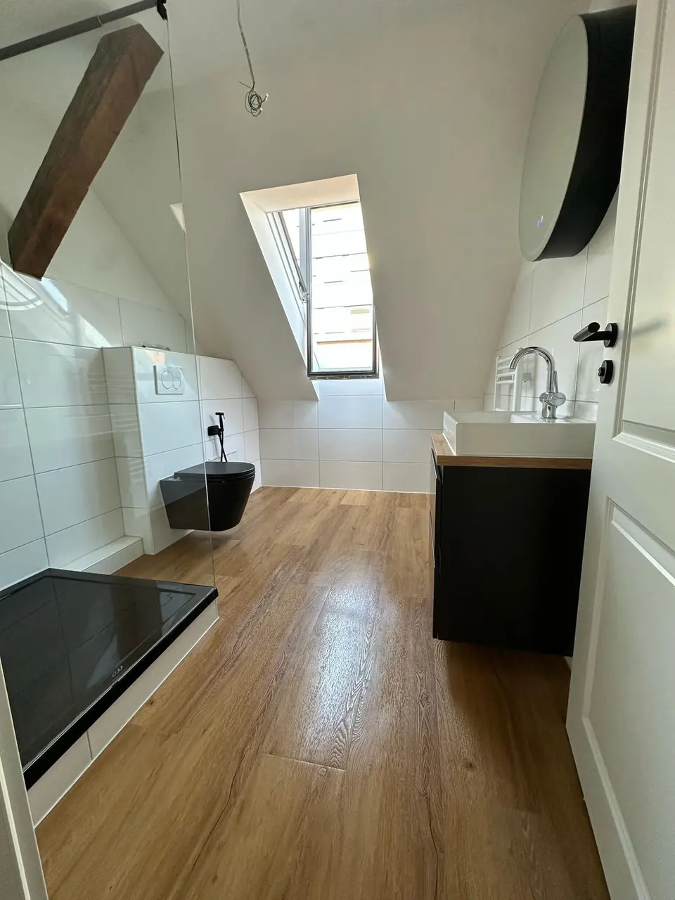 Echtes Referenzfoto eines fertiggestellten Dachgeschossbads mit Glasdusche