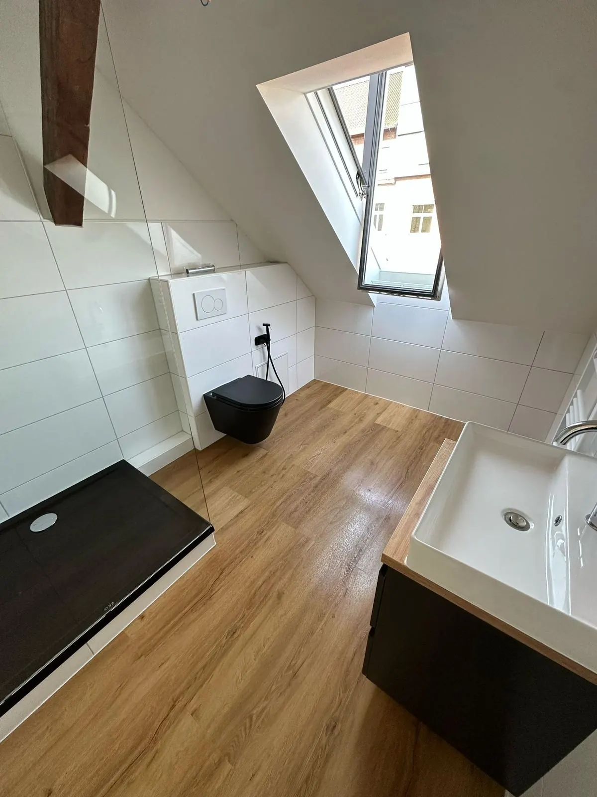 Echtes Referenzfoto eines fertiggestellten Dachgeschossbads mit WC, Dusche und Waschplatz