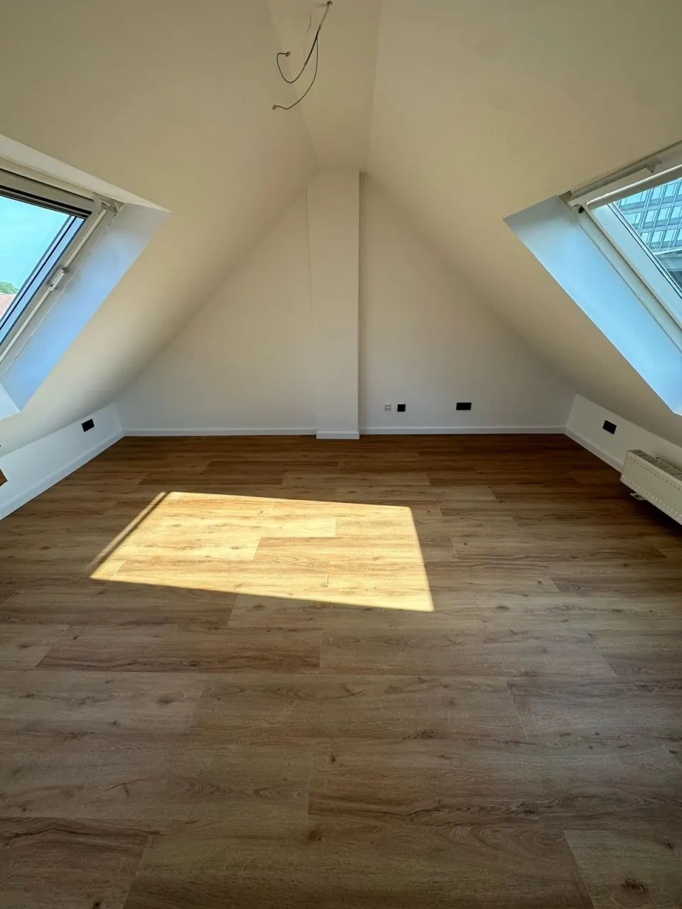 Echtes Referenzfoto eines renovierten Dachgeschosszimmers mit Dachfenster