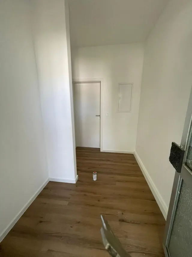 Echtes Referenzfoto eines renovierten Flurs mit Laminat und Treppenanschluss