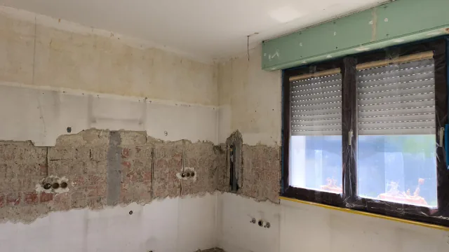 Küchenbereich nach dem Entfernen alter Wandbekleidungen mit Fenster und sichtbaren Anschlusszonen
