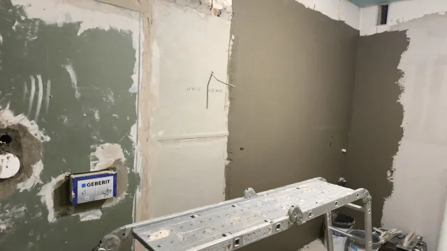 Badezimmer im Ausbau mit vorbereiteten Wandflächen, Installationsbereich und Arbeitsgerüst