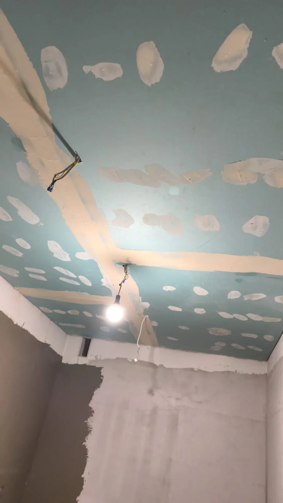 Baddecke mit grünen Feuchtraumplatten, gespachtelten Fugen und Baustellenbeleuchtung